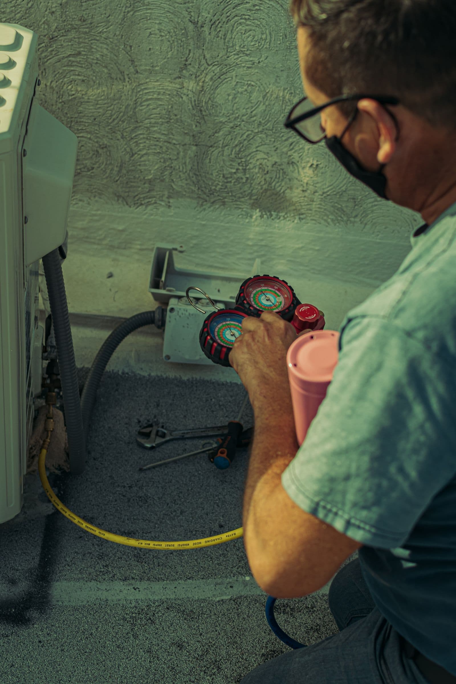 Technician checking a residential air-conditioning system with service gauges