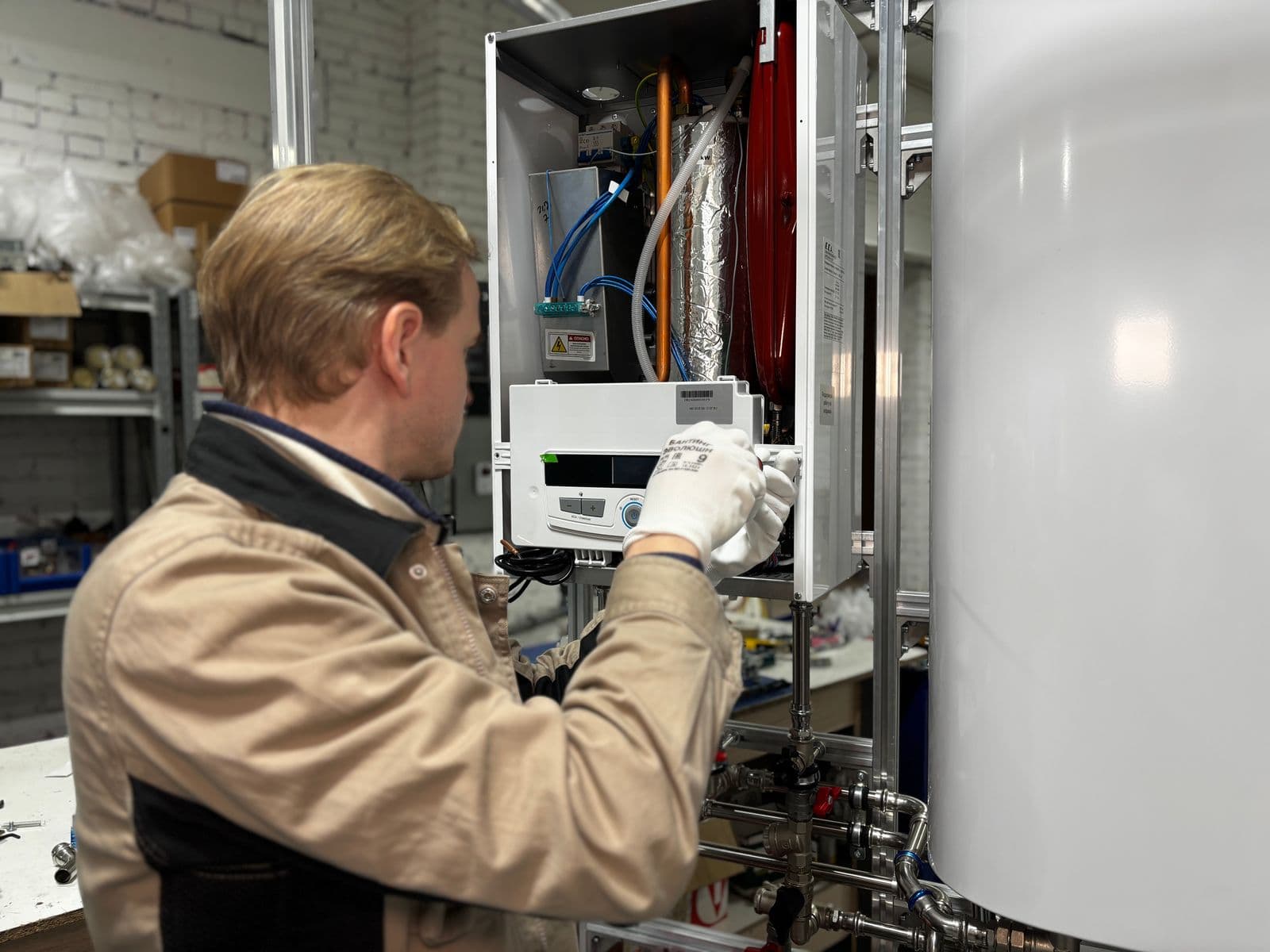Stock technician inspecting heating-system equipment in a workshop