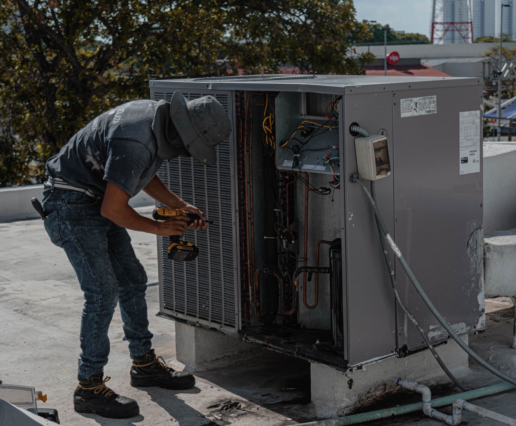 HVAC technician working on an open outdoor heating and cooling unit