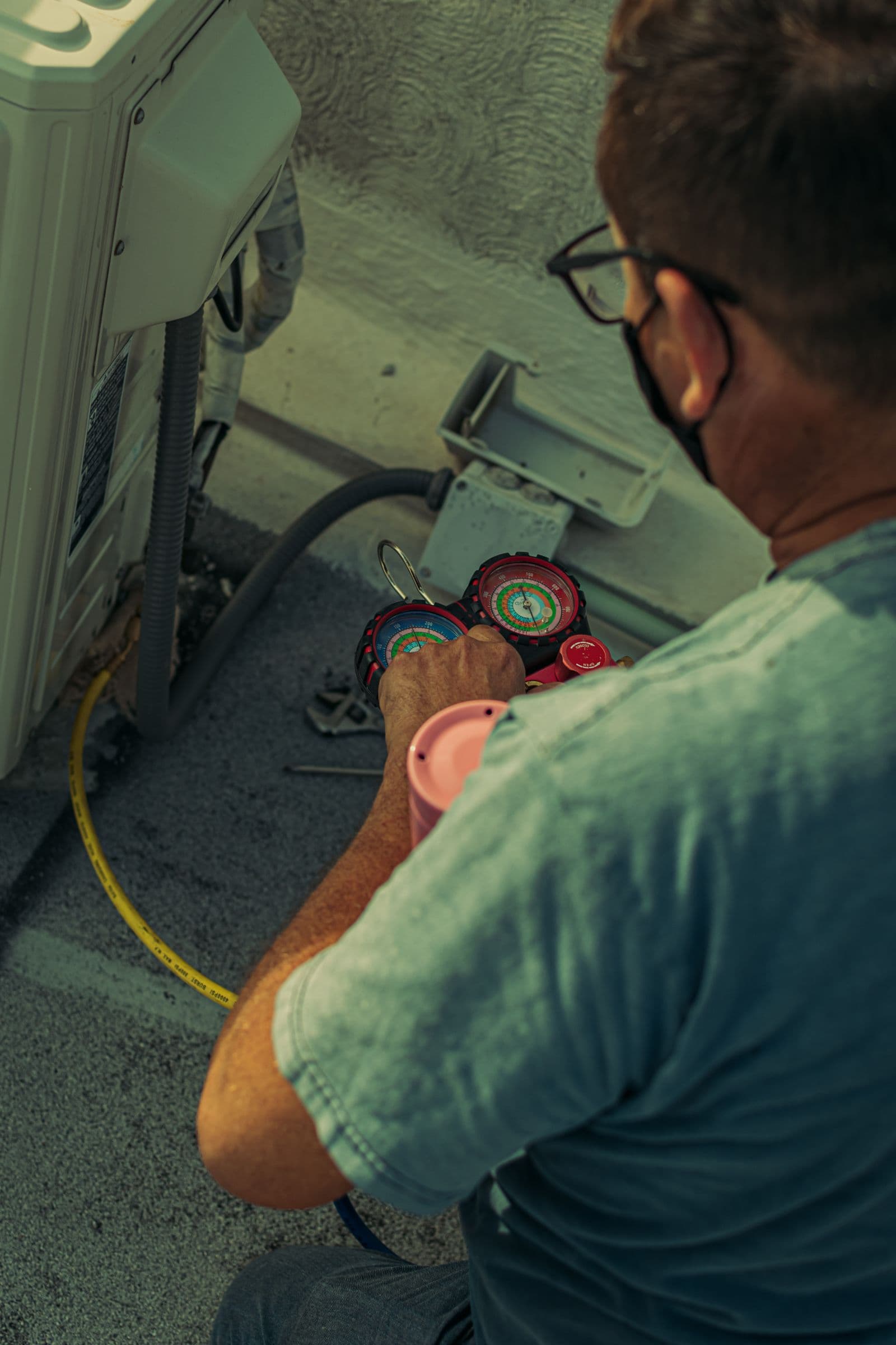 HVAC technician checking system pressure with diagnostic gauges